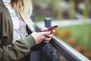 Woman scrolling through phone alone