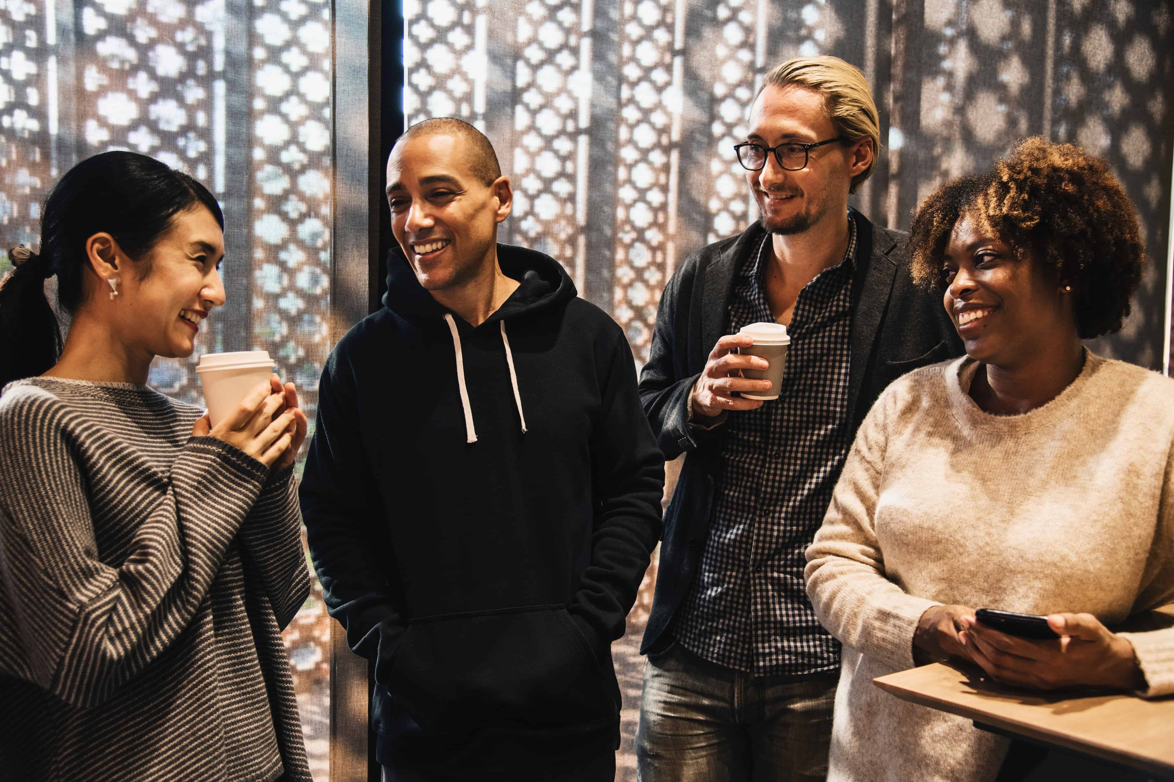 Four adults at coffee shop one woman on phone