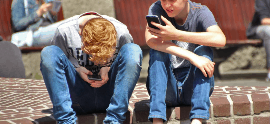 Two young boys on cell phones