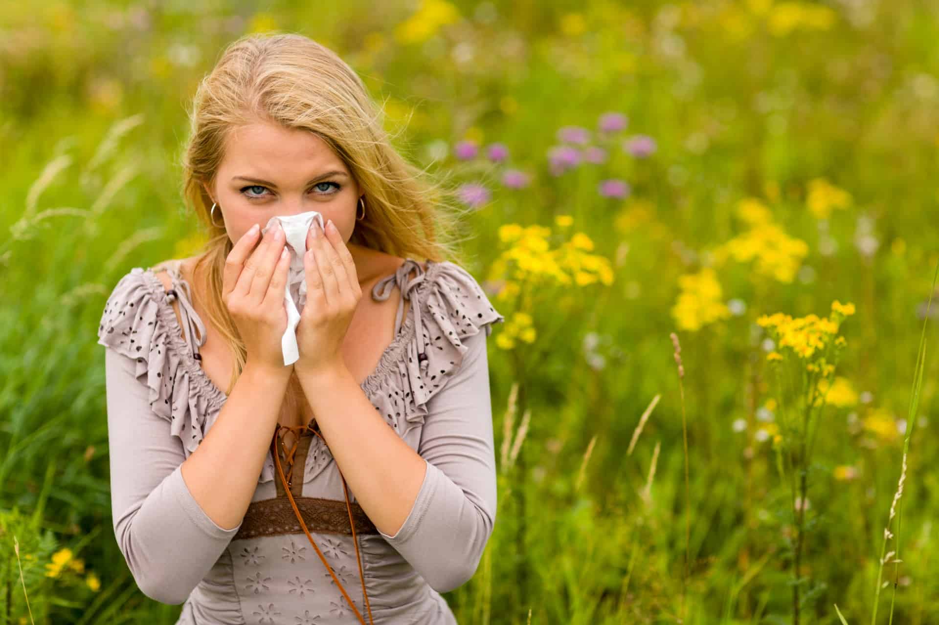 Woman blowing her nose into tissue