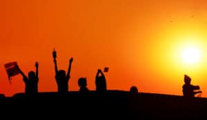 Kids playing in field at sundown